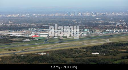 aerial view of Manchester International Airport looking North across the 2 main runways towards the city centre skyline Stock Photo