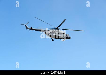Russian military helicopter Mi-8 (NATO codification: Hip) in flight on clear blue sky background Stock Photo