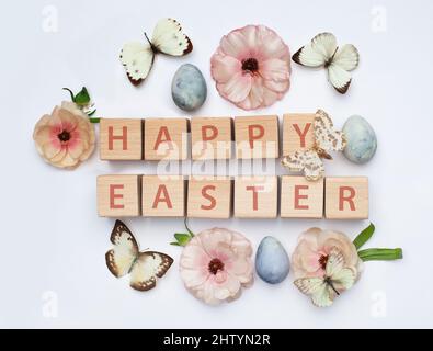Easter floral background. Pink spring flowers, butterfly and blue Easter egg on white Stock Photo