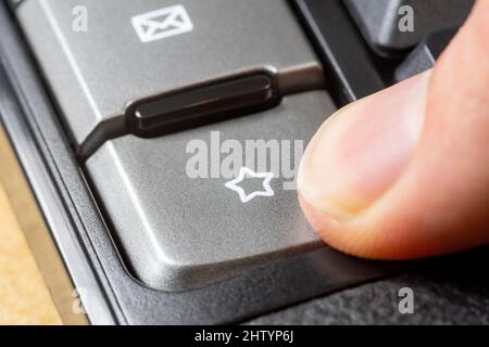 Finger pressing a star symbol icon button, man clicking the favorite bookmark key, liking, adding to favorites, bookmarking a webpage, website seo rat Stock Photo