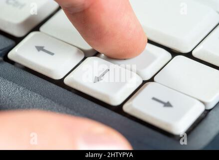 Finger pressing an up arrow key, going forward, moving forward progress, upward movement, advancement, forwards and upwards abstract concept, laptop c Stock Photo