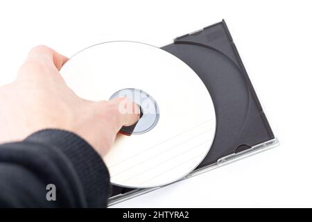 Anonymous man, hand taking out or putting in a simple blank empty CD or DVD disc in a CD-ROM box storage container. Movie, film, software, data copyin Stock Photo