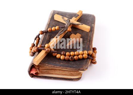 Old dusty prayer book, a cross and a rosary laying on top of it Christianity Catholicism traditional religious symbols, group of objects detail, close Stock Photo