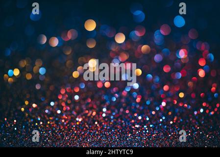 Neon bokeh background with blue, yellow and pink colors on dark. Blur halftone glitter texture. Blurred night lights glow. Stock Photo