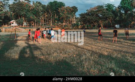 playing football in the field in the afternoon in Wonogiri Stock Photo