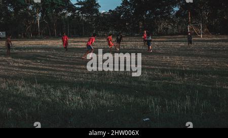 playing football in the field in the afternoon in Wonogiri Stock Photo