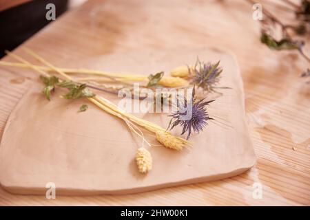 rolling out the clay mass for sculpting a wall panel Stock Photo
