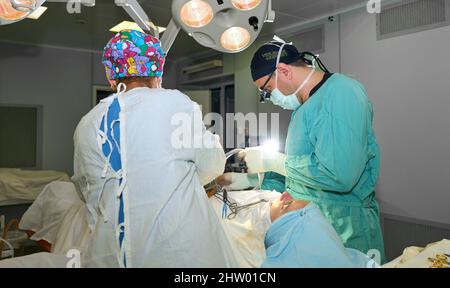 In the hospital operating room. An international team of professional surgeons and assistants works in a modern operating room. Professional doctors c Stock Photo