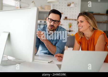 Programmers cooperating at IT company developing apps Stock Photo