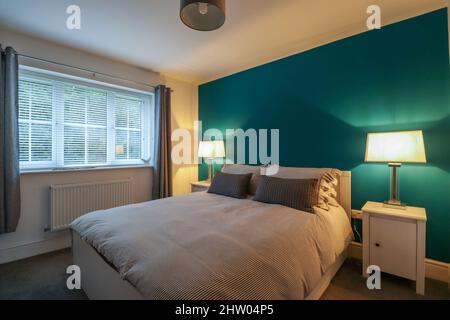 King sized bedroom with simple decor in a modern new build home Stock Photo
