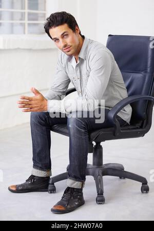 Young, handsome and stylish. Shot of a handsome young sitting in a chair. Stock Photo