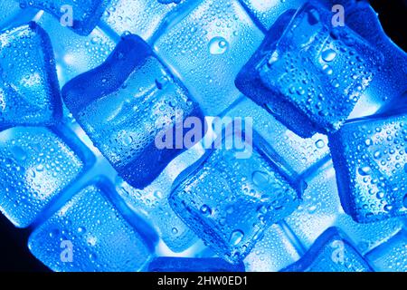 Ice cubes with blue backlight in the freezer close-up in full screen selective focus Stock Photo