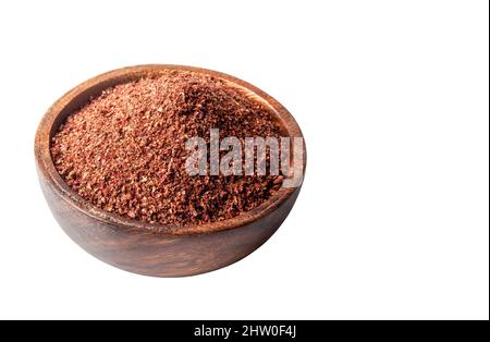 Granulated sumac dried in bowl on white background Stock Photo