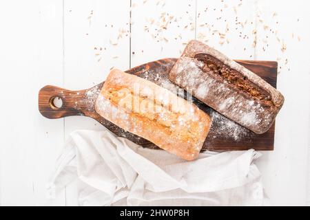 top view of the kitchen board with two loaves of freshly baked chibatta bread made of rye and wheat flour. fresh pastries Stock Photo