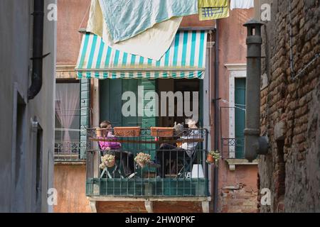 young couple on a balcony in venice above canal Stock Photo