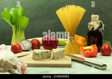 Raw pasta of various types and spices on a wooden table. View from above. Macaron on wooden table, space for text Stock Photo