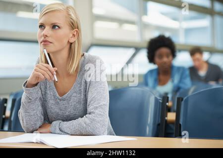 Focused on her future. A beautiful young student listening intently in a lecture hall. Stock Photo