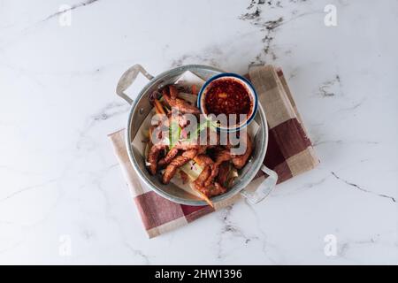 Fried Pork Strips with chili Sauce in a dish isolated on mat top view on grey marble background Stock Photo