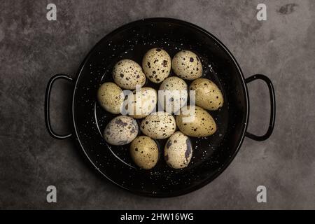 Quail eggs in a frying pan on a marble table in a top view Stock Photo