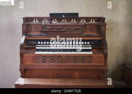 Old wooden harmonium inside a church Stock Photo