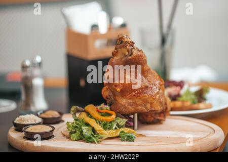 Roasted knuckle of pork with boiled cabbage, bread, horseradish and mustard served with salad Stock Photo