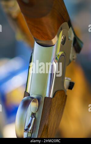 Close-up of an open, unloaded double-barreled shotgun at a sports shooting range. Blurred background. Stock Photo