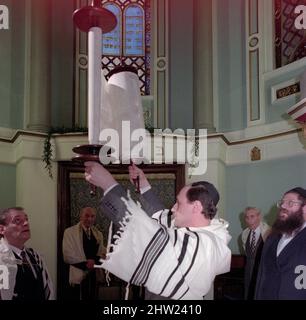 The new Sefer Torah is raised high for the Hagbah ceremony. The Chief Rabbi Jonathan Sacks was the guest of honour for the adding the final letters into a new Sefer Torah at the Birmingham Hebrew Congregation Singers Hill synagogue on Sunday 15 March 1998. Members of the congregation as well as the Chief Rabbi added a single letter each. Stock Photo