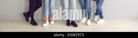 Group of young people in jeans, pants, trainers and classic shoes standing in the studio Stock Photo