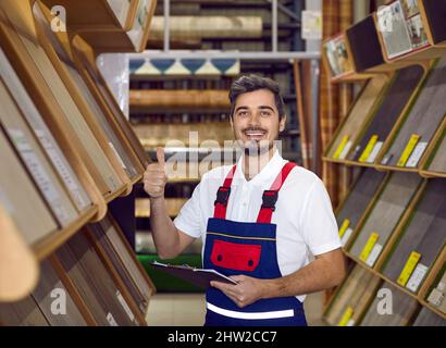 Happy seller of laminate flooring promising best quality, giving thumbs up and smiling Stock Photo