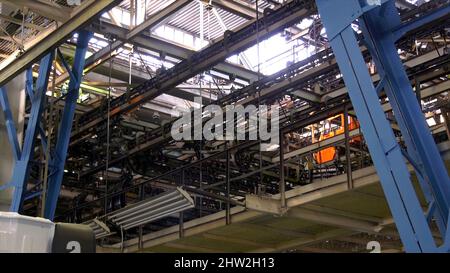 Car production line with unfinished cars. Scene. Technological production line at the plant. Conveyor line in a huge factory. Stock Photo