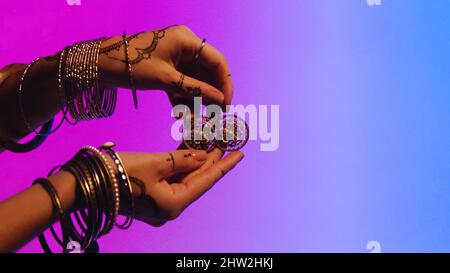 Indian woman with earrings in hand. Stock. Woman gives a man her jewelry, a gift as a sign of friendship. Stock Photo