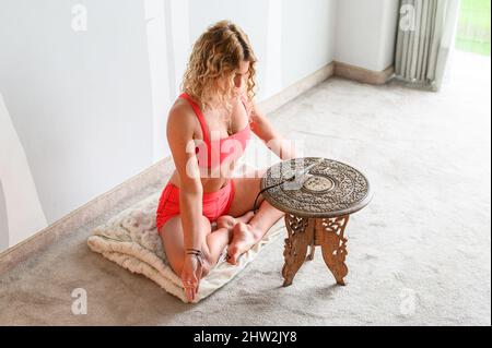 Fitness coach teaching yoga online to group of people. People practicing yoga with trainer via video conference Stock Photo