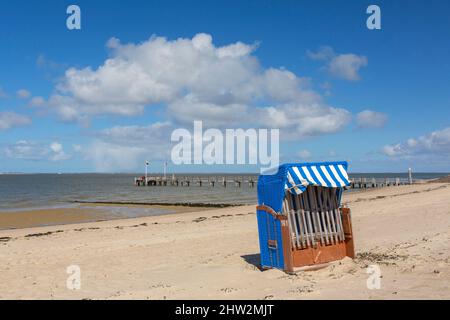 Roofed wicker beach chair and wooden jetty / pier at Utersum on the island of Föhr in the district of Nordfriesland, Schleswig-Holstein, Germany Stock Photo