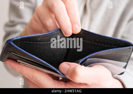 Man hand showing an open empty wallet close up. Poverty, cost control expenses, spent too much, not enough cash, lost money concept. Top above view. Stock Photo
