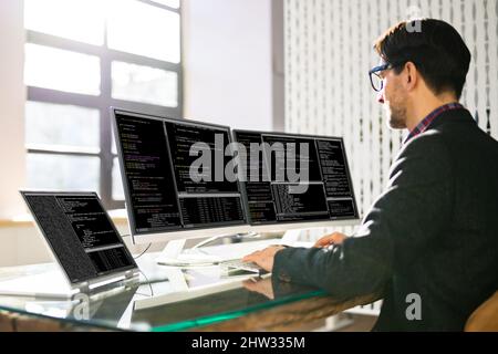 Computer Programmer Writing Program Code On Computer In Office Stock Photo