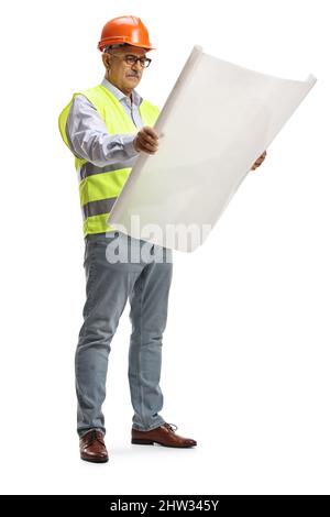 Full length portrait of a male engineer standing and reading a blueprint isolated on white background Stock Photo