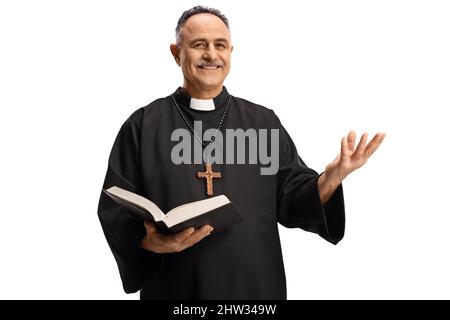 Smiling mature priest holding an open bible isolated on white background Stock Photo