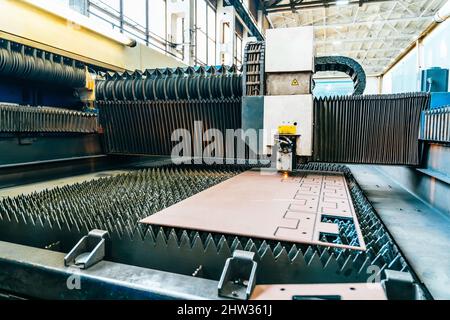 Process of cutting metal. CNC Laser plasma cutter machine in industrial metalwork factory. Stock Photo