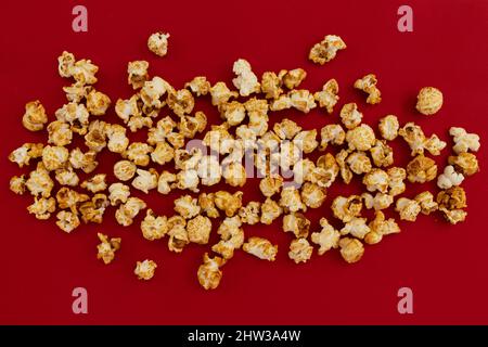 frame of caramel popcorn and empty space for text on red background, sweet snacks Stock Photo