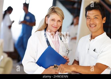 Caring health professionals. Shot of two medical professionals smiling at the camera. Stock Photo