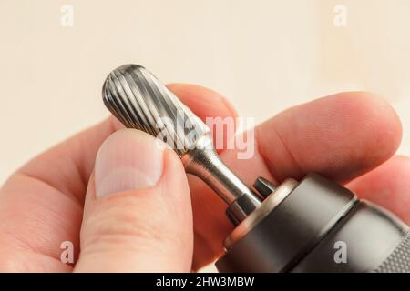 Engraving tool for wood or metal. Insert the engraving attachment into the drill chuck. Wood processing and polishing. Stock Photo