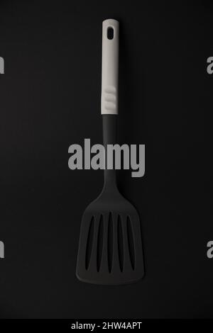 cooking spatula on black background, close up, copy space Stock Photo