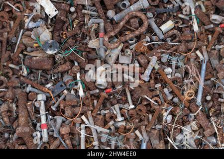 Background of small nuts, srews, bolts and pieces of string most of which are rusty Stock Photo