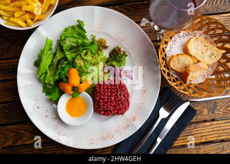 Beef steak tartare with raw egg yolk and salad Stock Photo
