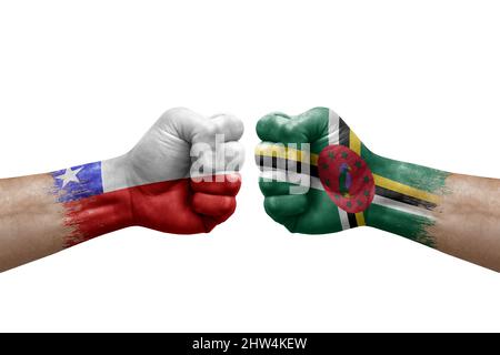 Two hands punch to each others on white background. Country flags painted fists, conflict crisis concept between chile and dominica Stock Photo