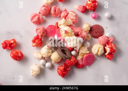 Colorful red and pink candied popcorn with mixed candies pile Stock Photo