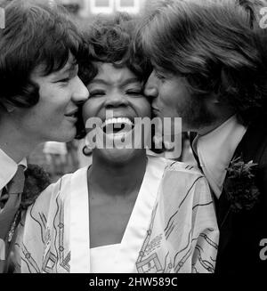 American Pop singer P.P. Arnold receives a kiss from  her new husband, manager Jim Morrison (left) and Barry Gibb of the Bee Gees pop group on her wedding day  October 1968 Stock Photo