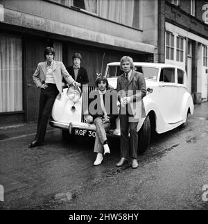 The Bee Gees examine an early christmas present from agent Robert Stigwood, a 1948 Rolls Royce Silver Wraith, 12th December 1967.  The car was given as a special gift to mark & celebrate reaching 1 million record sales of their single Massachusetts.  Four of the five members of the group look over the car & give it a polish and clean.   Mr Stigwood had the car completely re-upholstered and painted & teh engine was overhauled.  Pictured: Colin Peterson, Vince Melouney, Barry Gibb & Robin Gibb in Adams Row, Mayfair (Robin Gibb was not available for photo) Stock Photo