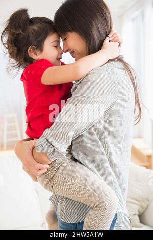 Hispanic mother and daughter hugging Stock Photo