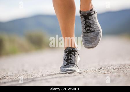 Close-up of feetÂ of woman jogging in desert landscape Stock Photo